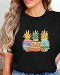 Person wearing a black t-shirt with colorful pineapple design and 'Hello Summer' text.