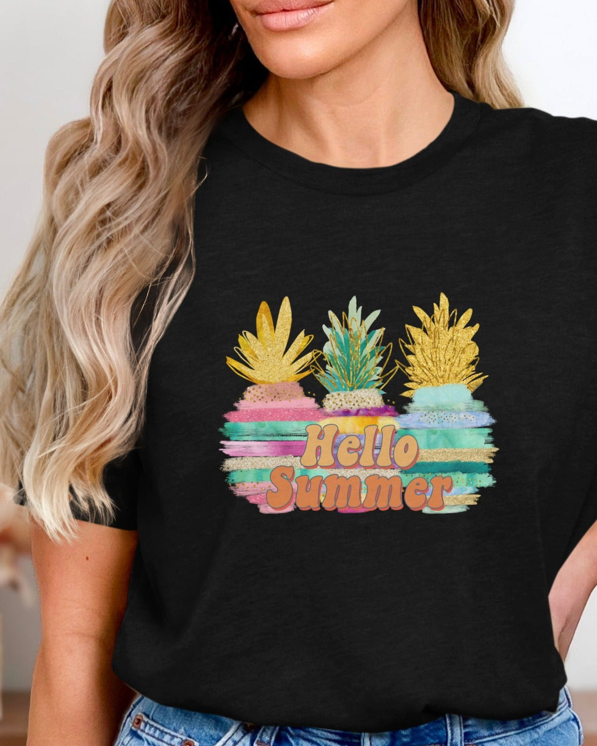 Person wearing a black t-shirt with colorful pineapple design and 'Hello Summer' text.