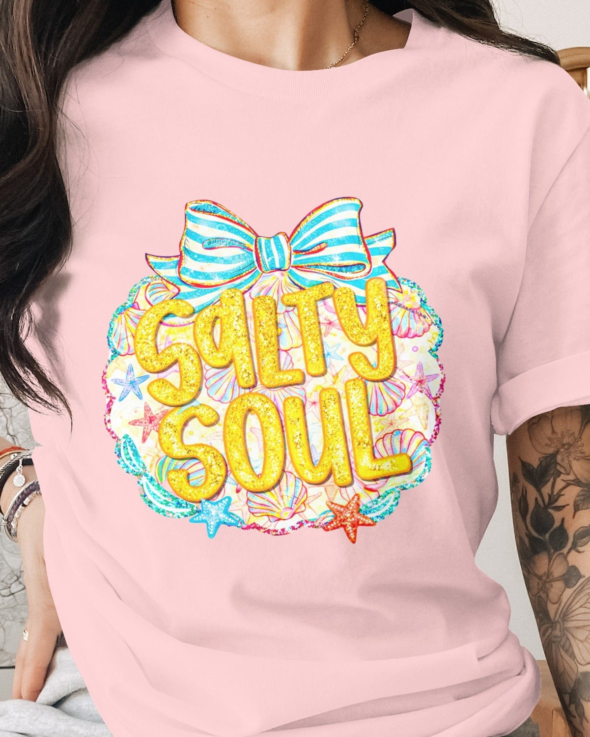 Person wearing a pink t-shirt with 'Salty Soul' design