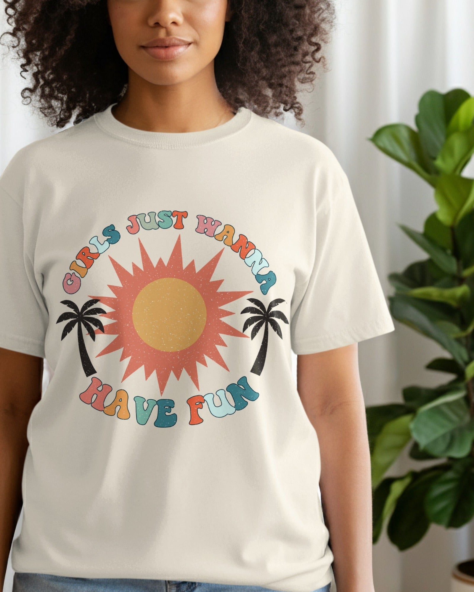 Person wearing a t-shirt with a colorful graphic design featuring a sun and palm trees.