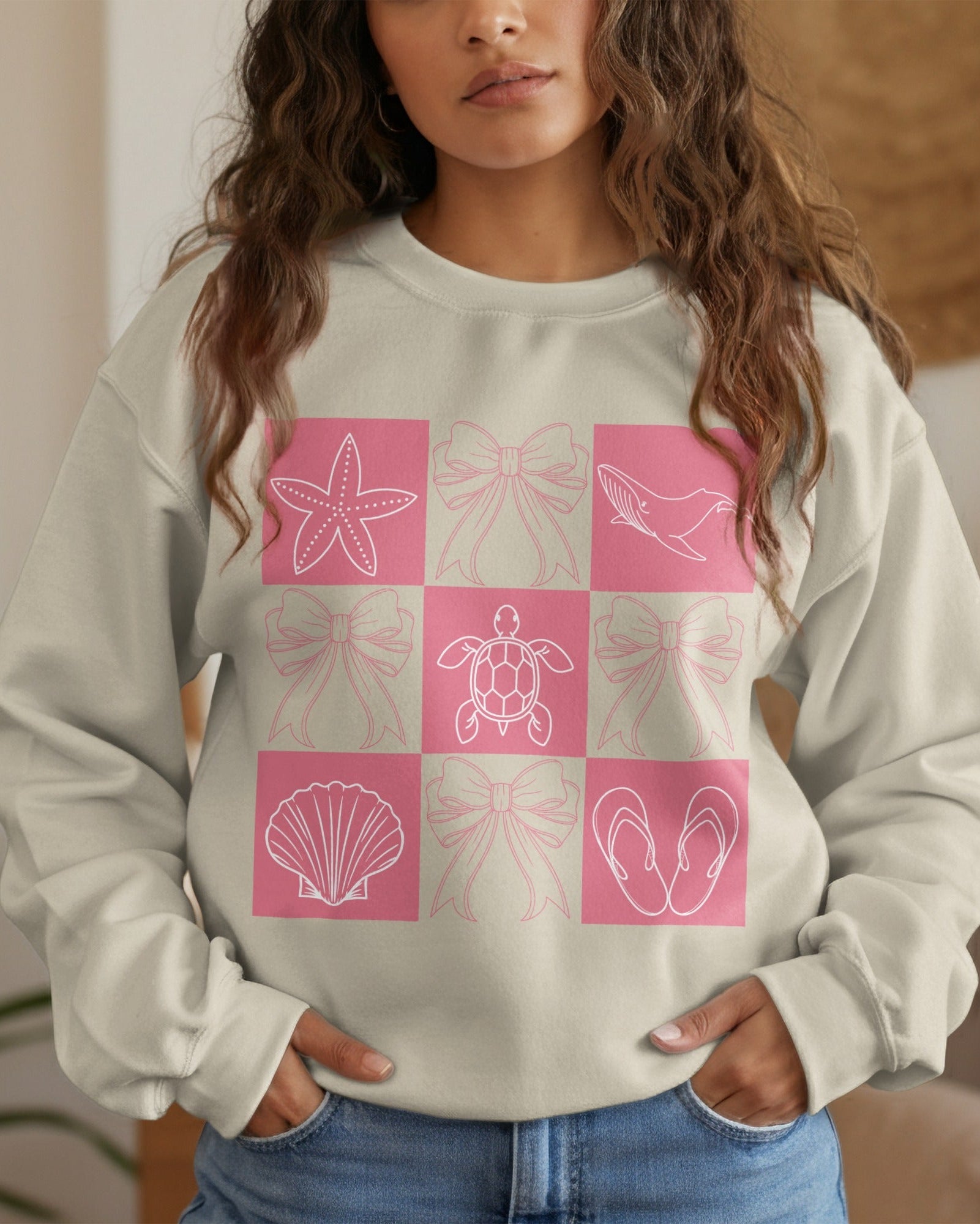 Woman wearing a light gray sweatshirt with pink geometric patterns in a checkered design.