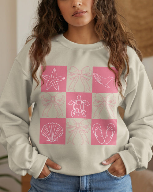 Woman wearing a light gray sweatshirt with pink geometric patterns in a checkered design.