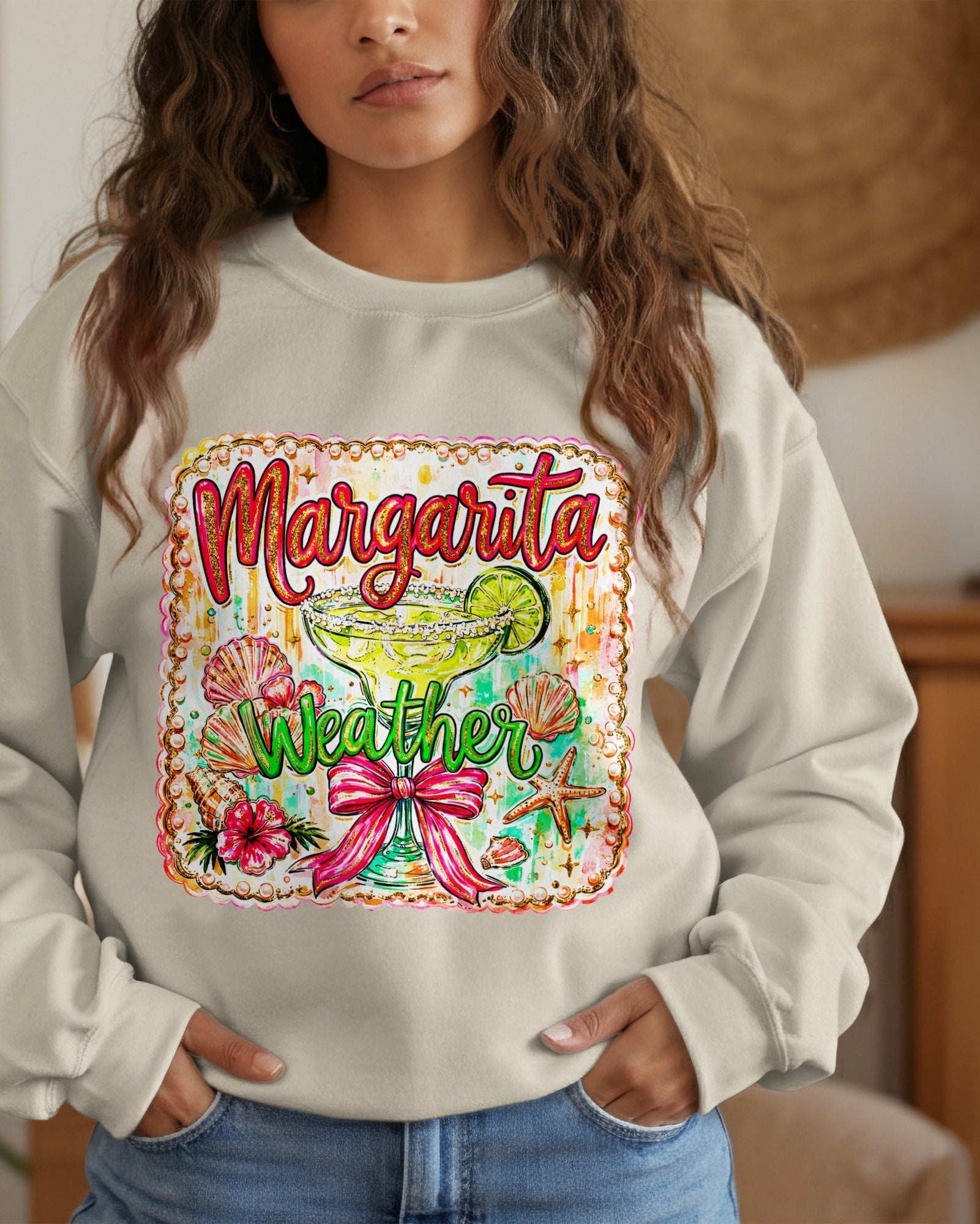 Woman wearing a sweatshirt with 'Margarita Weather' design in a home setting