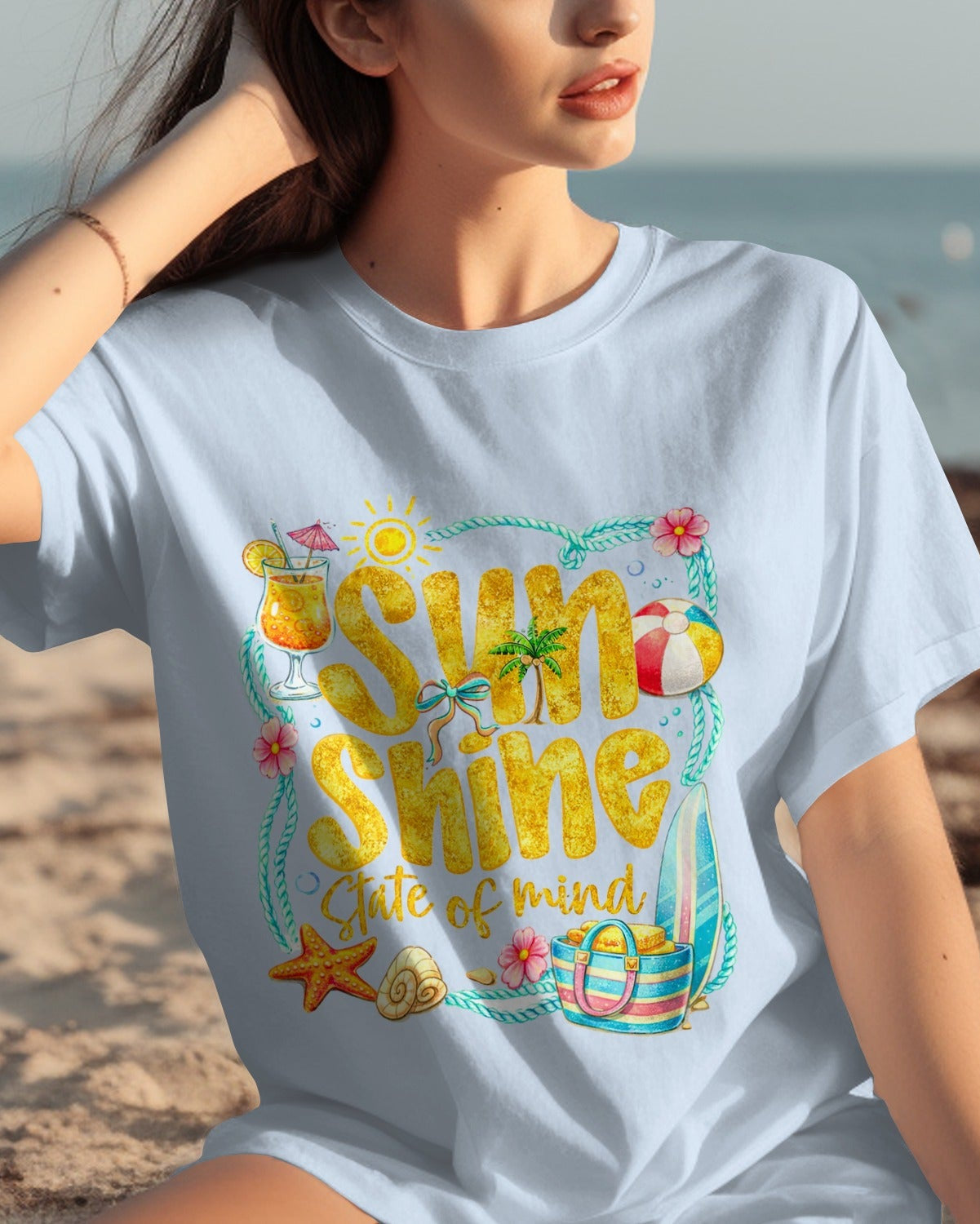 Woman wearing a white t-shirt with 'Sunshine of my Life' design on a beach.